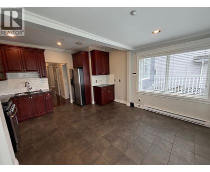 A kitchen with dark wood cabinets and a white backsplash.
