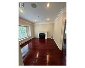 A room with a fireplace and wood flooring.