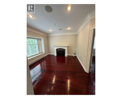 A room with a fireplace and wood flooring.