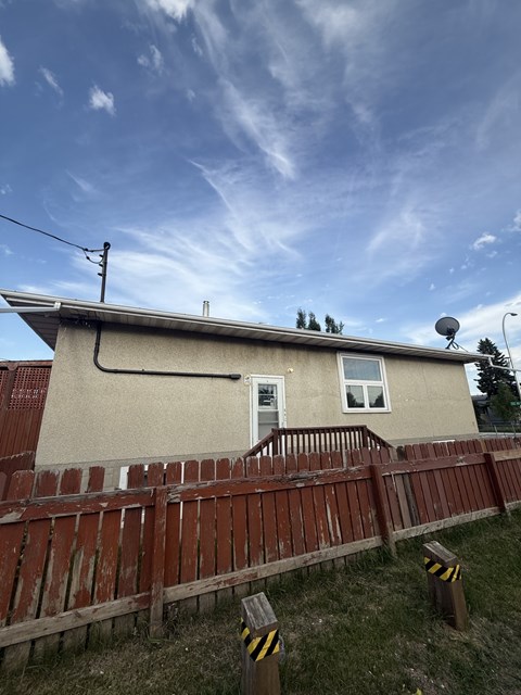 A house with a brown fence in front of it.