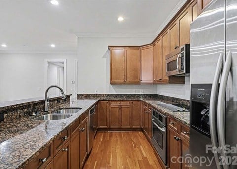A kitchen with wooden cabinets and granite countertops.