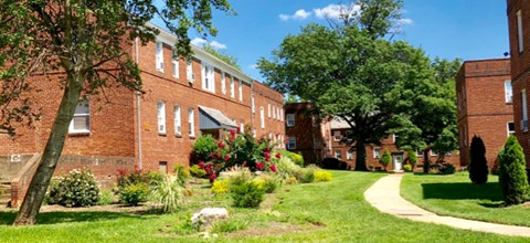 A green lawn in front of a red brick building.