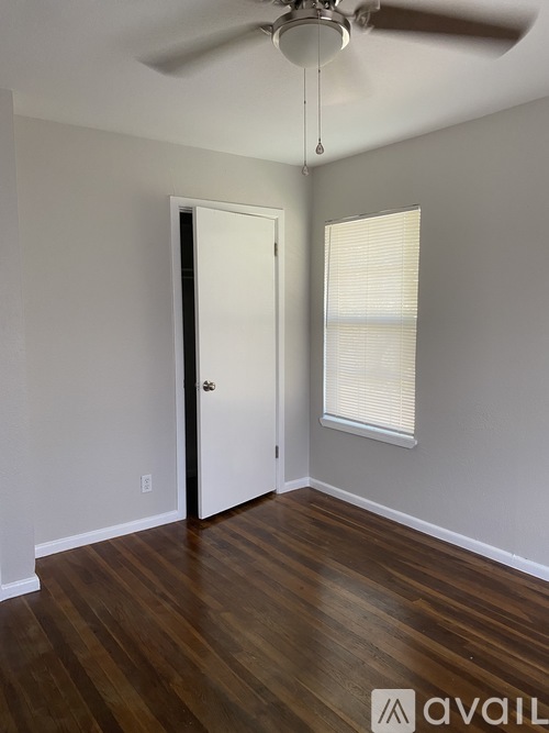 A room with a ceiling fan and wooden flooring.