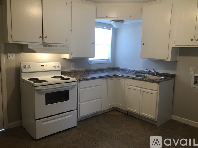 A kitchen with white appliances and cabinets.