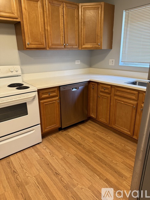 A kitchen with wooden cabinets and a white stove top oven.