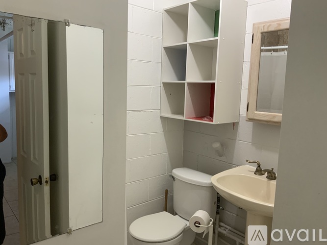 A bathroom with a toilet, sink, and medicine cabinet.