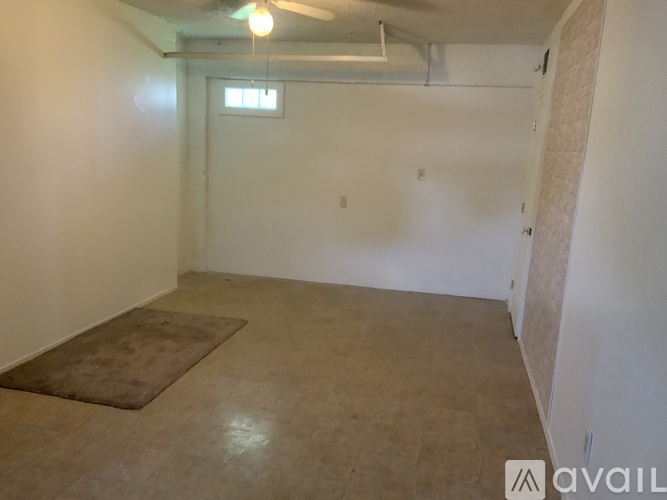 A room with a rug on the floor and a ceiling fan.