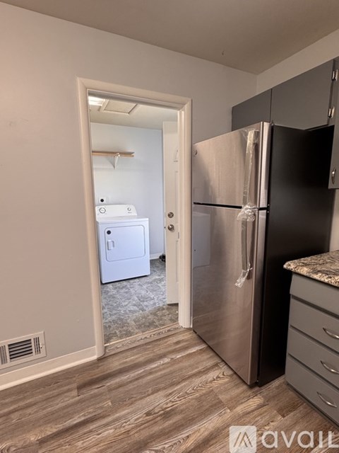 A kitchen with a black fridge and a white dishwasher.
