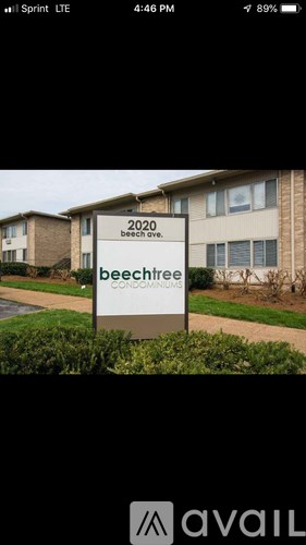 A sign for Beechcrest Condos is displayed in front of a building.