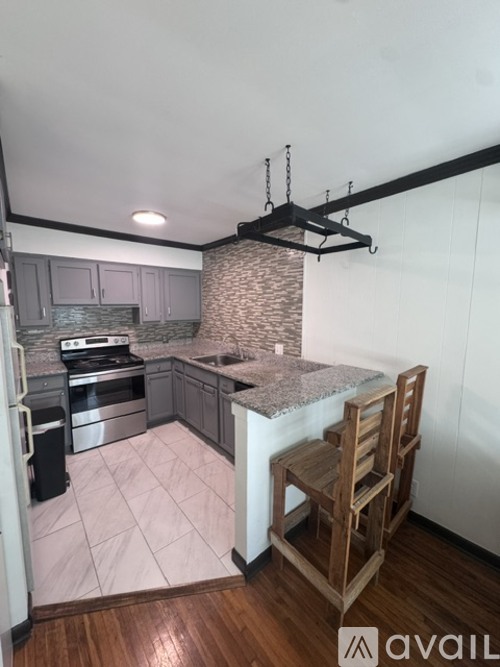 A kitchen with a marble countertop and wooden flooring.