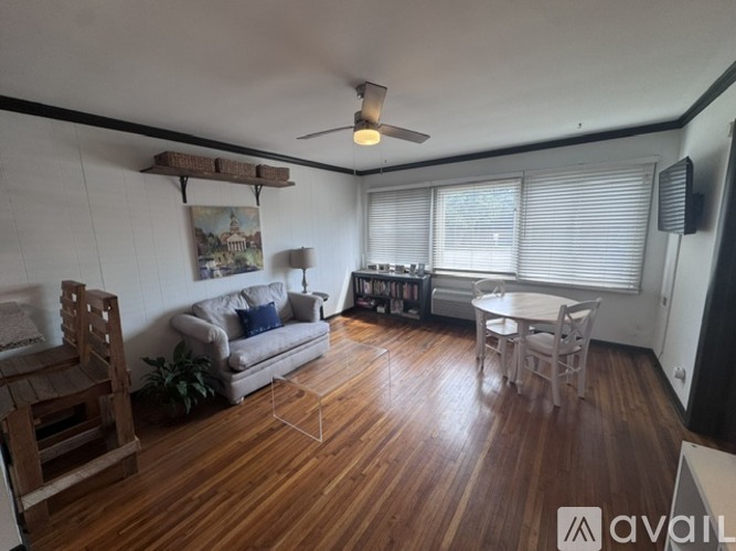 A living room with wooden floors and a ceiling fan.