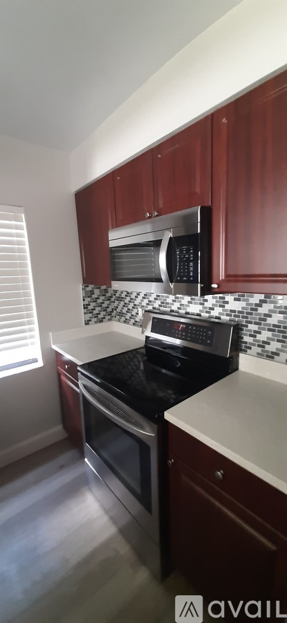 A kitchen with wooden cabinets and a black and white checkered backsplash.