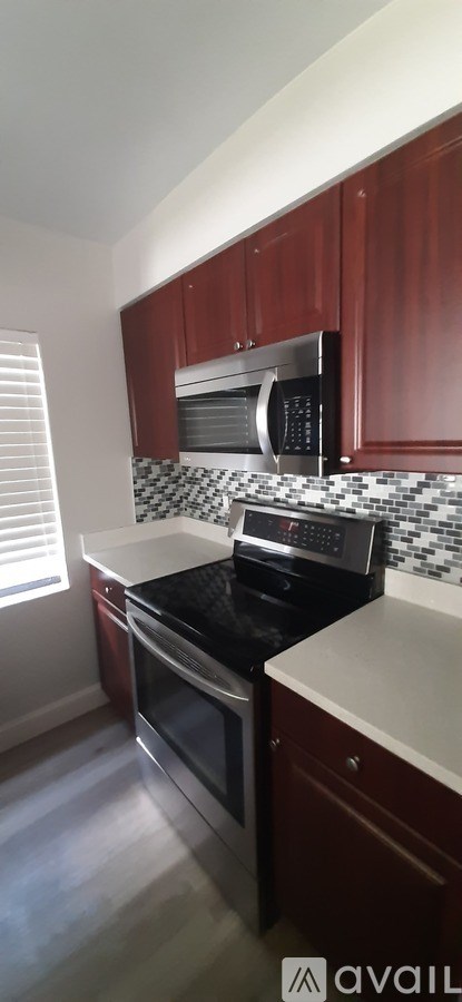 A kitchen with wooden cabinets and a black and white checkered backsplash.