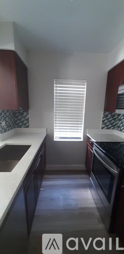A kitchen with dark wood cabinets and white countertops.