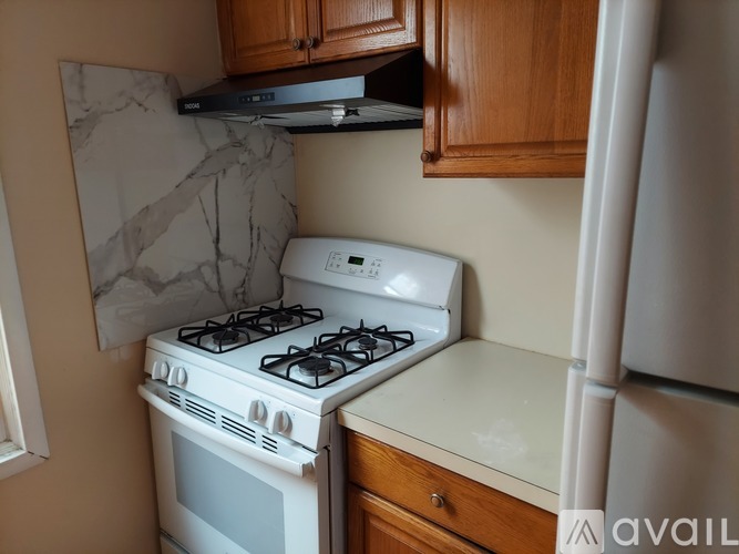 A white gas stove is in a kitchen with wooden cabinets.