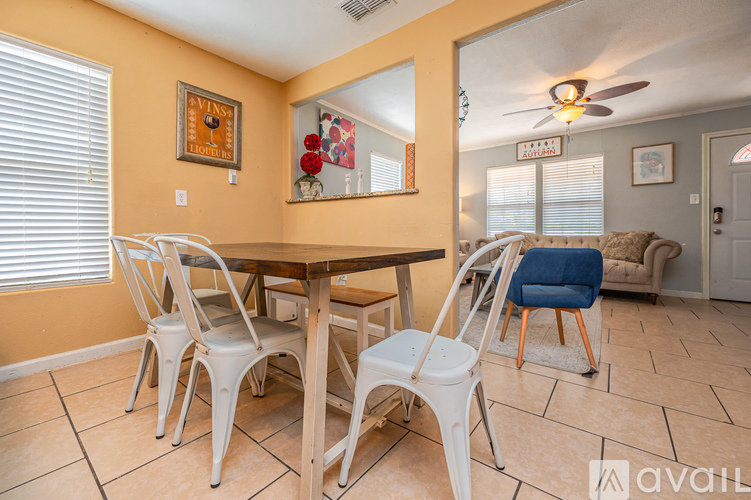 A dining room with a wooden table and white chairs.