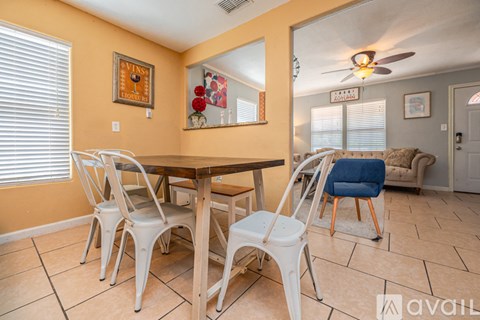 A dining room with a wooden table and white chairs.