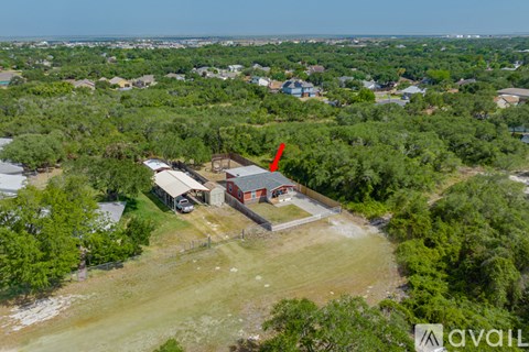 An aerial view of a property with a red arrow pointing to a building.