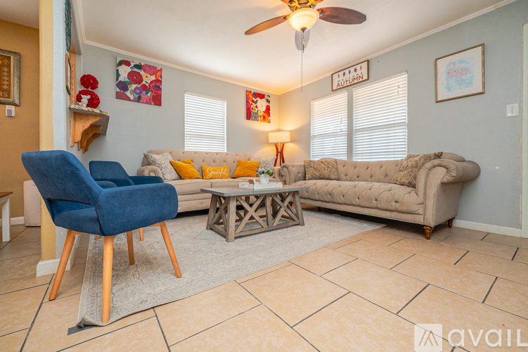 A living room with a blue chair and a beige couch.