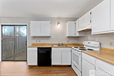 A kitchen with white cabinets and a black dishwasher.