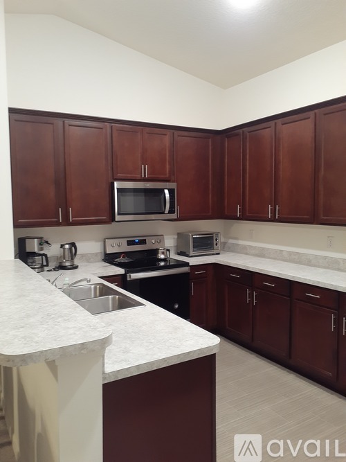 A kitchen with brown cabinets and a white counter.