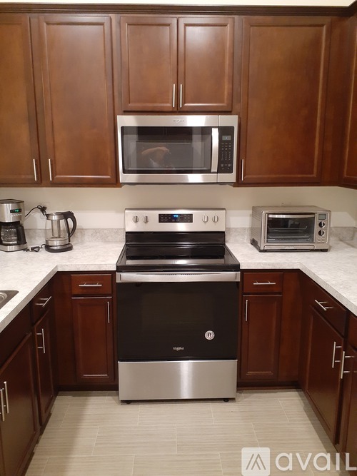 A kitchen with a black stove top oven and a microwave above it.