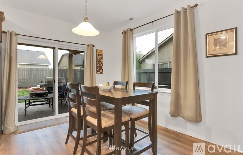 A dining room with a wooden table and chairs.