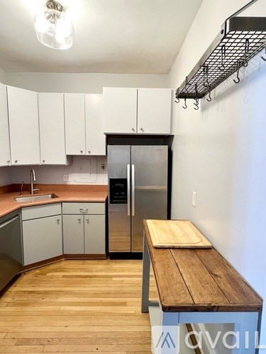 A kitchen with a wooden table and a refrigerator.