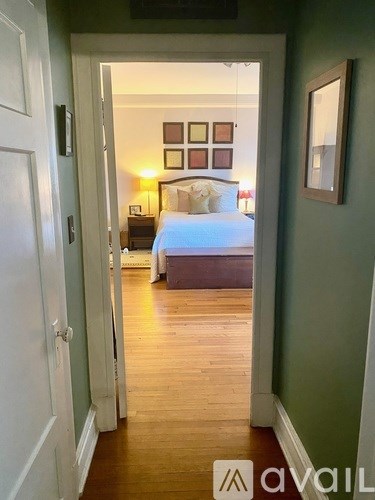 A bedroom with a bed, nightstand, and lamp.