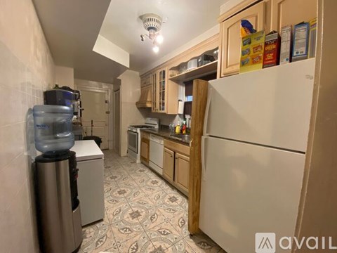 A kitchen with a white refrigerator and a patterned floor.