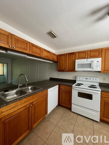A kitchen with brown cabinets and a white stove.