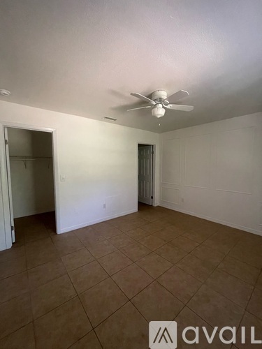 A room with a ceiling fan and tiled floor.