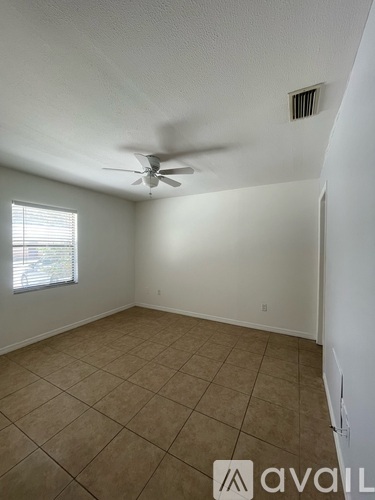 A room with a ceiling fan and tiled floor.