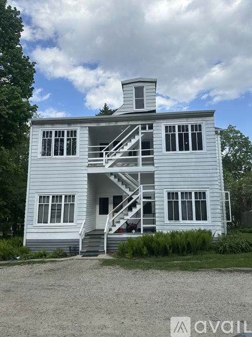 A two-story house with a grey exterior and a white roof.