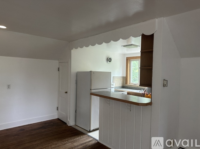 A kitchen area with a refrigerator and a window.