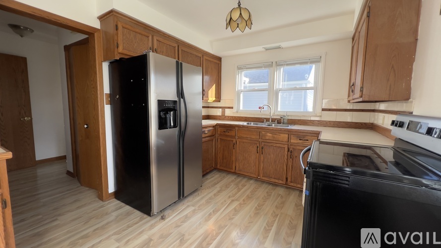 A kitchen with a black fridge and stove top oven.