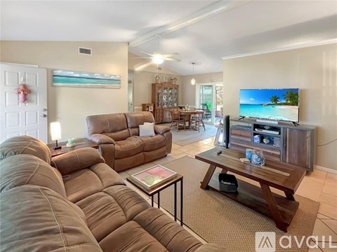 A living room with a large couch and a flat screen TV.