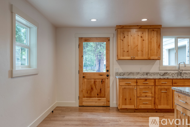 A kitchen with wooden cabinets and a marble countertop.