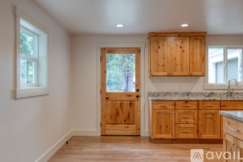 A kitchen with wooden cabinets and a marble countertop.
