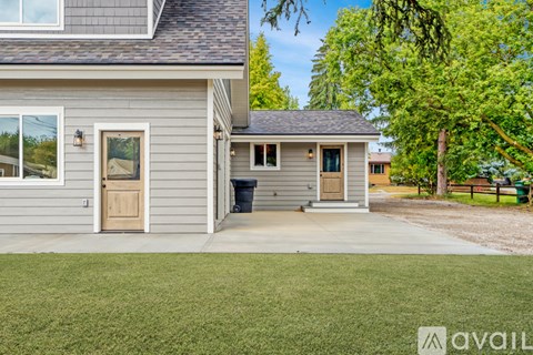 A house with a grey exterior and a brown door is available for rent.