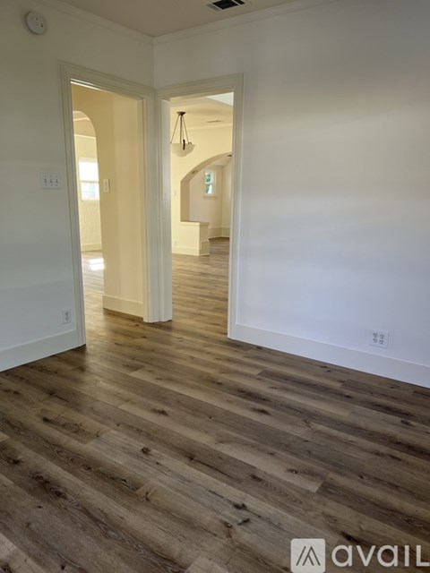 A room with wooden flooring and white walls.