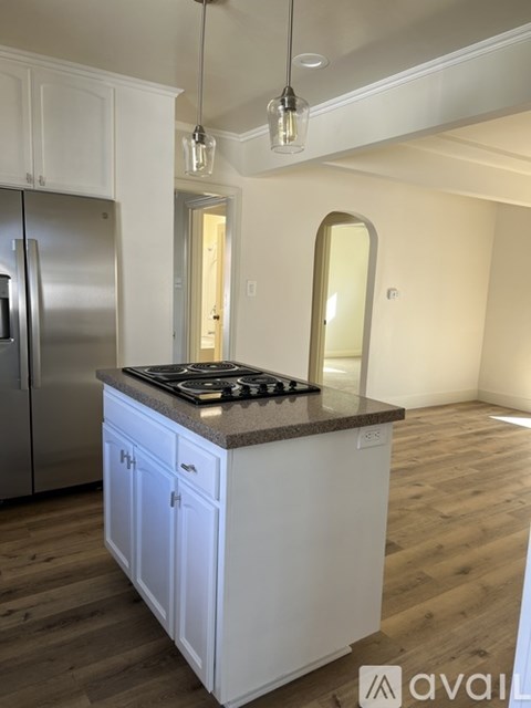A kitchen with white cabinets and a stainless steel refrigerator.