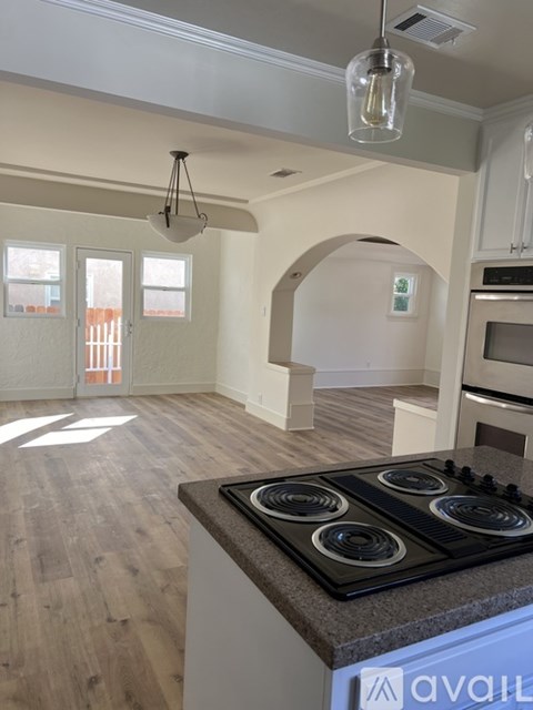 A kitchen with a stove top oven and a sign that says "available".