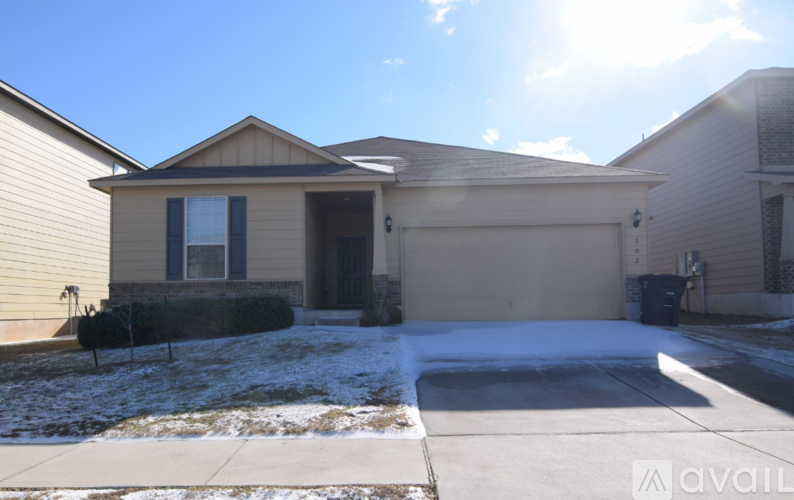 A house with a garage and a driveway covered in snow.