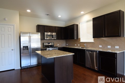 A kitchen with dark brown cabinets and stainless steel appliances.