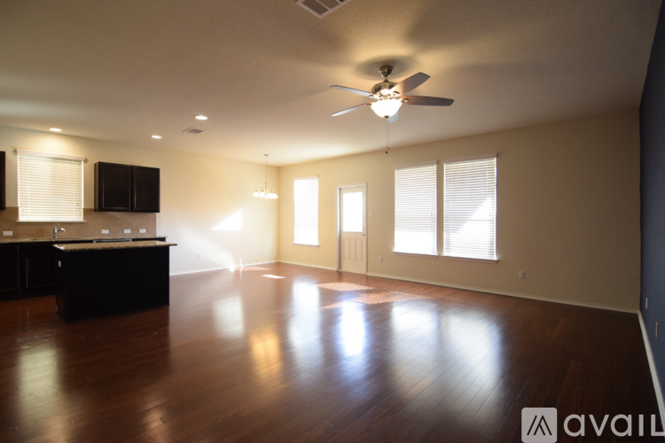 A spacious room with a ceiling fan and wooden flooring.