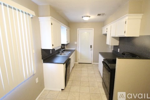 A kitchen with black countertops and white cabinets.
