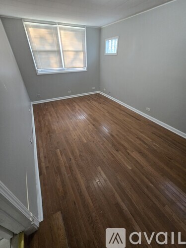 A room with wooden flooring and a window.