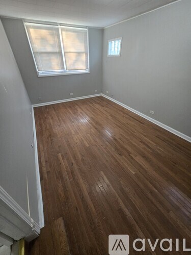 A room with wooden flooring and a window.