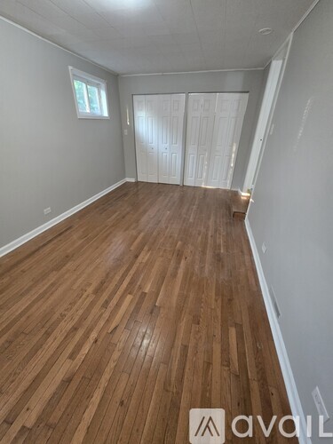 A room with wooden flooring and white walls.